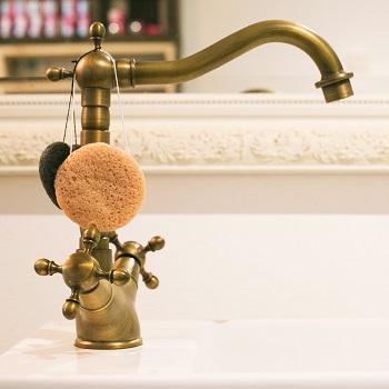 Fancy kitchen faucet with small round sponges hanging from it
