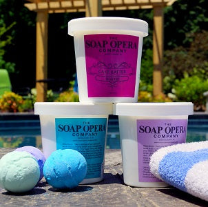 Containers of sugar whip and bath bombs by a pool